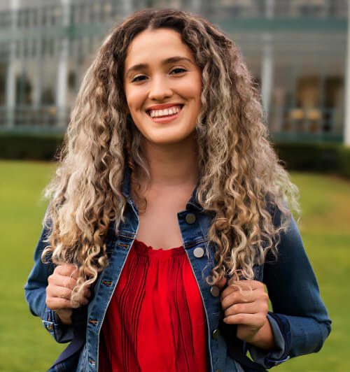 A woman with long hair is smiling for the camera.